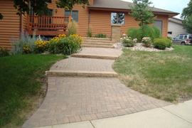 Sloped front entrance walk with VersaLok steps, pillar, and holland pavers.