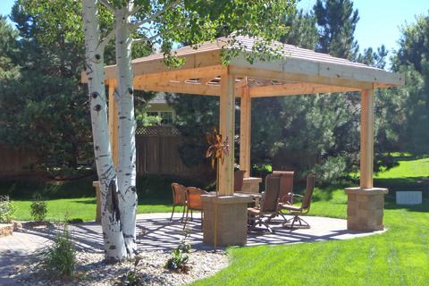 Pitched overhead with pillars around the posts and a cobblestone paver patio.